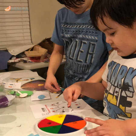 Two multiethnic multiracial boys doing I Luv Chinese crafts.